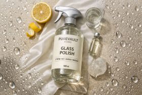 Butelka sprayu do polerowania szkła z cytryną i małymi buteleczkami na tle z kroplami wody