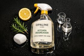 Butelka środka do odtłuszczania kuchni z cytryną i rozmarynem na czarnej powierzchni