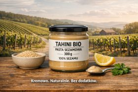 Słoik pasty sezamowej Tahini Bio na drewnianym stole z miseczką sezamu i plasterkiem cytryny