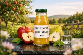 Butelka soku bio jabłko i gruszka na stole z owocami i szklanką wody