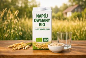 Kartonik napoju owsianego bio z miską płatków i pustą szklanką na drewnianym stole będący przykładem na wizualizacje produktowe