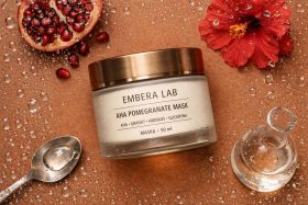 Słoik maski do twarzy z granatem i hibiskusem na mokrej powierzchni