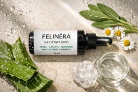 Butelka kropli do czyszczenia uszu Felinéra z naturalnymi składnikami na kamiennym tle