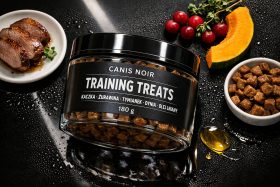 Pojemnik z przysmakami dla psów Canis Noir na czarnym tle z mięsem, dynią i żurawiną będący przykładem na wizualizacje produktowe