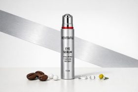 Butelka serum pod oczy RevitaFill z metalicznym aplikatorem i ziarnami kawy obok