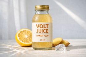 Butelka soku imbirowo-yuzu z kroplami wody i plasterek cytryny obok