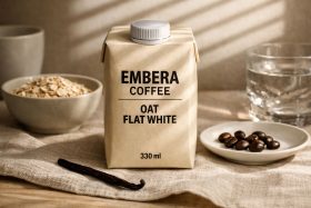Kartonik kawy Embera Oat Flat White 330 ml na lnianym obrusie z ziarnami kawy i płatkami owsianymi będący przykładem na wizualizacje produktowe