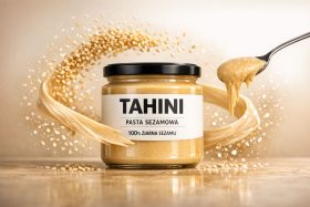 Słoik pasty sezamowej tahini z łyżką i ziarnami sezamu w ruchu