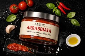 Słoik sosu Arrabbiata z pomidorami, chili, bazylią i czosnkiem na czarnym tle