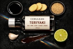 Butelka sosu teriyaki z imbirem, czosnkiem, limonką i sezamem na czarnym tle