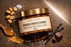 Słoik masła orzechowego z orzeszkami, solą, miodem, wanilią i kakao na brązowym tle