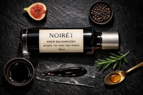 Butelka kremu balsamicznego Noiret z figą, pieprzem i rozmarynem na czarnym tle będąca przykładem na wizualizacje produktowe