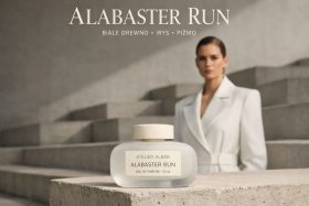 Butelka perfum Alabaster Run na tle kobiety w białym płaszczu i schodów