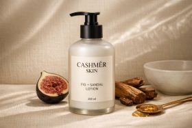 Butelka lotionu Cashmêr Skin z pompką na tle figi i drewna sandałowego