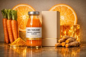 Butelka soku tłoczonego z marchewką, pomarańczą i kurkumą obok składników i opakowania