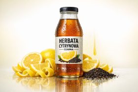 Butelka czarnej herbaty cytrynowej z kroplami wody i plasterkami cytryny