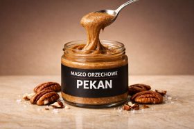 Słoik masła orzechowego pekan z łyżką nabierającą kremową pastę